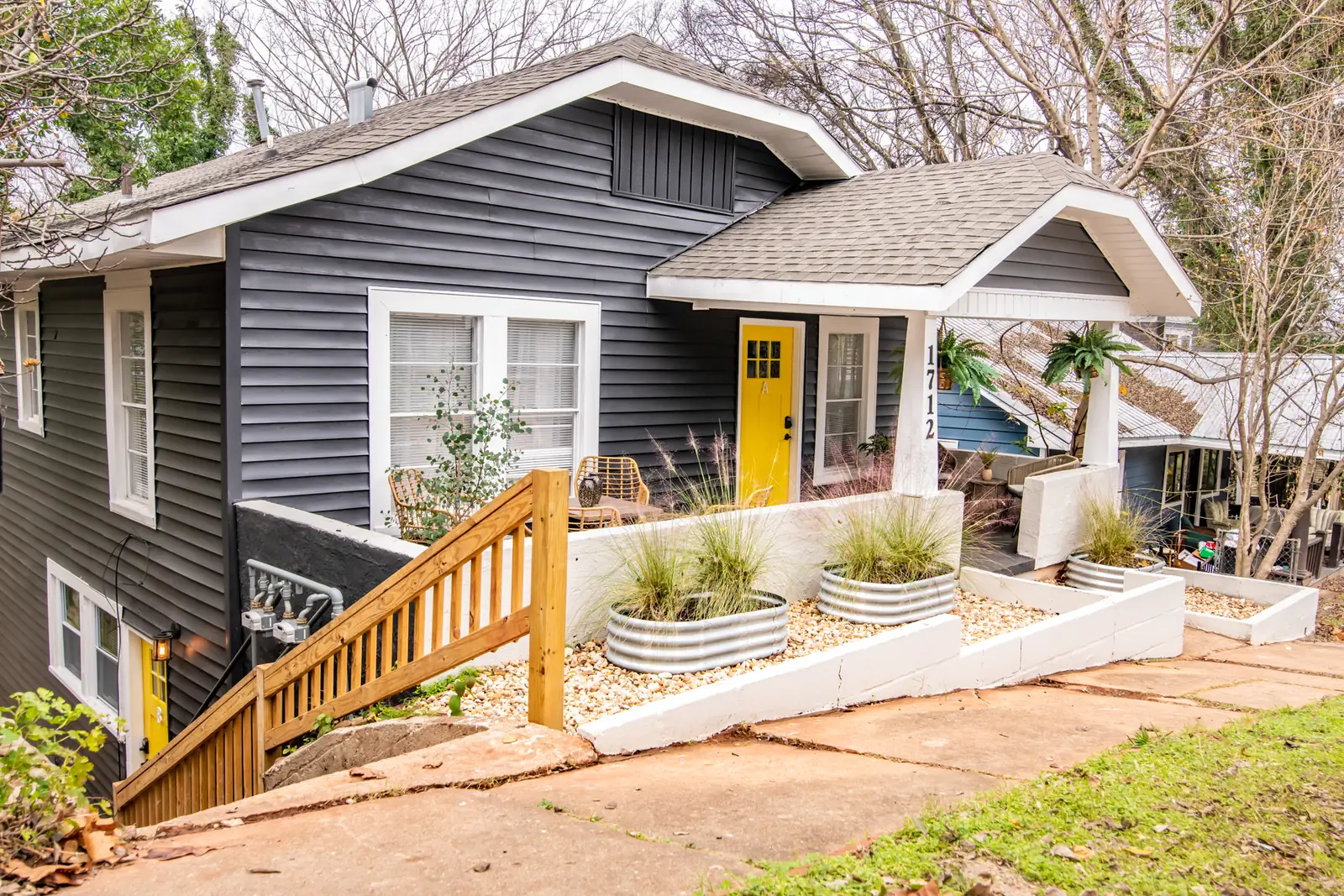 The front of the house with wood stairs and planters
