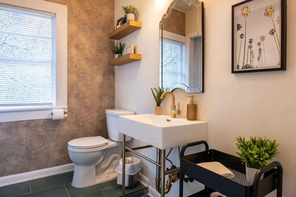 Unit A bathroom with a gold faucet and wall shelves
